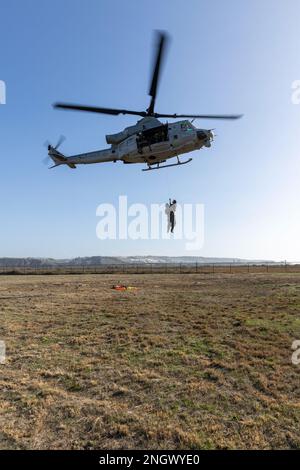 U.S. Marines with Marine Light Attack Helicopter Squadron 169, Marine Aircraft Group 39, 3rd Marine Aircraft Wing (MAW), lift Cpl. Jacob Dinwiddie, a UH-1Y Venom weapons and tactics instructor, and U.S. Navy Master Chief Petty Officer Ryan Grant, a departmental leading chief petty officer with Helicopter Sea Squadron 3, during Steel Knight 23, on Imperial Beach, California, Nov. 29, 2022. The exercise provides 3rd MAW an opportunity to refine Wing-level warfighting in support of I Marine Expeditionary Force and fleet maneuver. Dinwiddie is a native of Indianapolis. Stock Photo