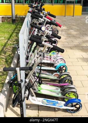 Hannover, Germany - May 24, 2019: Row of children's scooters parked outside school building Stock Photo