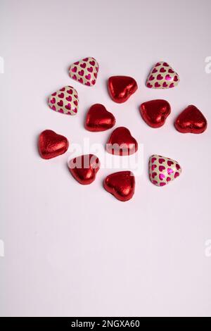 photo chocolate hearts in a colorful wrapper on a white background Stock Photo
