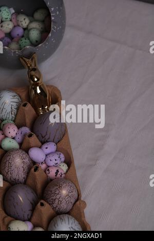 photo of quail and hens decorative eggs lying in a container on the table Stock Photo