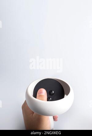 Hand holding virtual reality goggles controller on white background. Space for text. Virtual reality experience Stock Photo