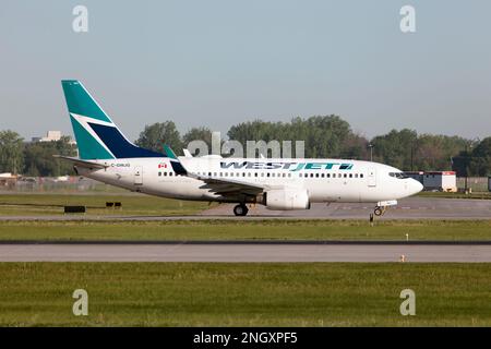 A WestJet Airlines Boeing 737-700 taxiing at Montreal Pierre Elliott Trudeau Int'l Airport. WestJet has two direct subsidiaries: WestJet Encore, which operates the Bombardier Q400; and WestJet Link, which operates the Saab 340B Stock Photo