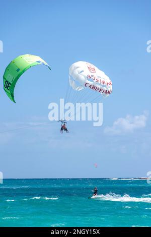 Man kite surfing and couple paragliding, Orient Bay (Baie Orientale), St Martin (Saint-Martin), Lesser Antilles, Caribbean Stock Photo