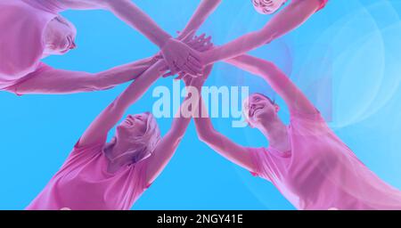 Composition of smiling friends stacking hands on blue background. teamwork, motivation and success concept digitally generated image. Stock Photo