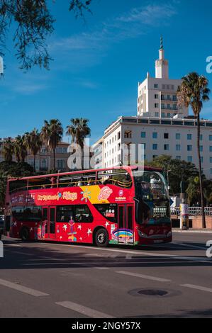 Malaga, Spain - January 16, 2023: Welcome to Malaga! Hop on the red sightseeing bus for a fun-filled tour of this beautiful city, with its stunning bu Stock Photo