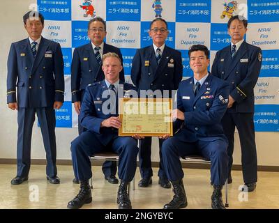 Members from the 31st Rescue Squadron, front, pose with a certificate of appreciation for saving a local man's life after receiving it from members of the Kadena Town Nirai Fire Dept., back, at the KTNFD, Japan, Dec. 1, 2022. The 31st RQS members train a host of skills in order to rescue and provide life saving care in a multitude of scenarios, allowing them to be ready for the unexpected. Stock Photo