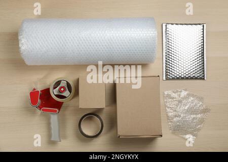 Flat lay composition with bubble wrap roll on wooden background Stock Photo