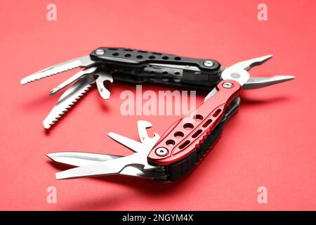 Compact portable multitool on red background, closeup Stock Photo