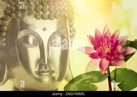 Beautiful golden Buddha sculpture and lotus flower on color background Stock Photo