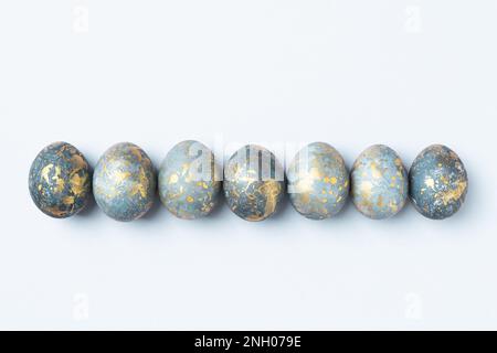Blue and gold Easter eggs in row. Easter background, greeting card, copy space, flat lay, Stock Photo