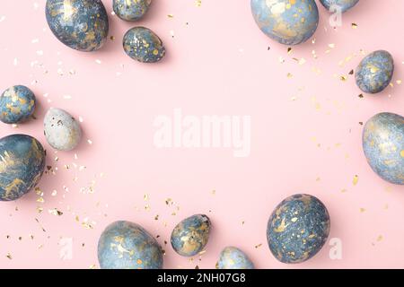 Blue Easter eggs frame, pink background with gold confetti. Chic Easter greeting card, copy space. Stock Photo