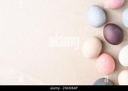 Natural dyed Easter eggs border on beige table. Eco concept, copy space. Pastel pale colors. Stock Photo