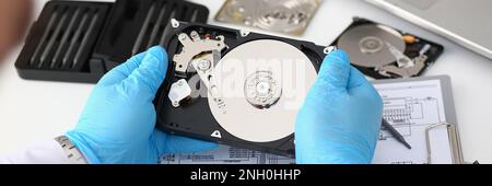 Technician repairs computer hard drive from motherboard Stock Photo