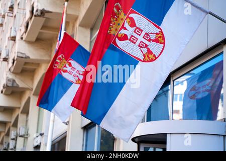 Close-up of Serbian flags on the facade of the building near the entrance. Belgrade, Serbia - 08.25.2022 Stock Photo