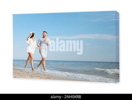 Photo printed on canvas, white background. Happy young couple running together on beach Stock Photo