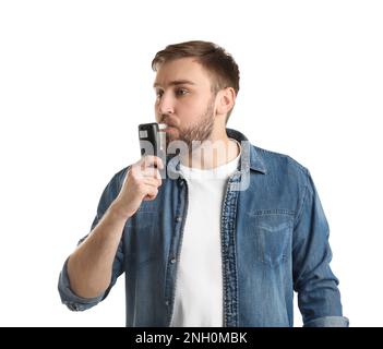 Man blowing into breathalyzer on white background Stock Photo