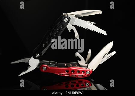 Compact portable colorful multitool on black background Stock Photo