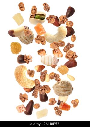 Delicious granola, nuts and dried fruits falling on white background. Healthy snack Stock Photo