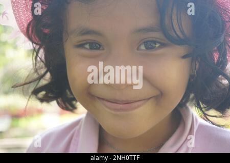 close up portrait smiling face of curly hair girl in hat Stock Photo