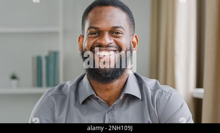 Happy joyful cheerful adult bearded African American male company manager leader boss CEO businessman guy man satisfied smiling in office looking at Stock Photo