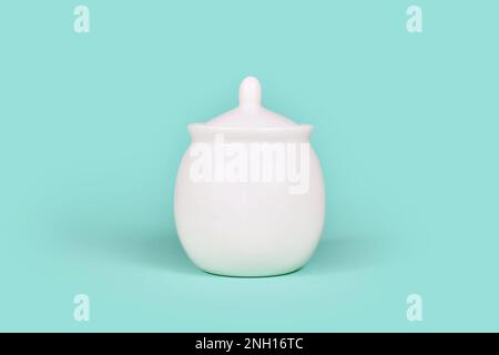 White sugar bowl on mint green background Stock Photo