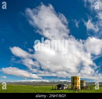 Heavy clouds over abandoned water tanks, early March, Carrizo Plain National Monument, California, USA Stock Photo