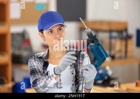 female carpenter using electric drill Stock Photo