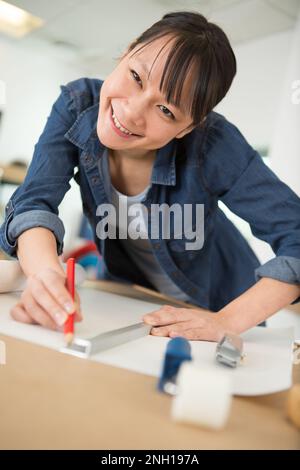 woman drawing a straight line on wallpaper Stock Photo