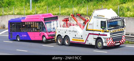 Heavy commercial DAF CF breakdown lorry hgv truck a specialist business vehicle towing St Albans public transport Uno bus colour M25 UK motorway road Stock Photo