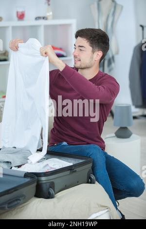 young man packing his bag and preparing for traveling Stock Photo
