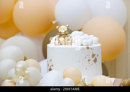 Creative gender neutral baby shower or birthday decoration in the garden. Bohemian style outdoor event set up with balloons. White cream peach caramel Stock Photo