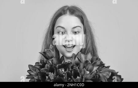 surprised child hold spring tulip flowers on yellow background Stock ...