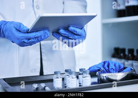 Using online resources to advance medicine. an unrecognizable scientist working on a tablet in the lab. Stock Photo