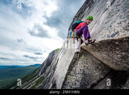 Man with tattoos rock climbing crack on rock wall - SuperStock