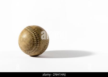 Old aged vintage brown baseball with shadow placed on white background in studio Stock Photo