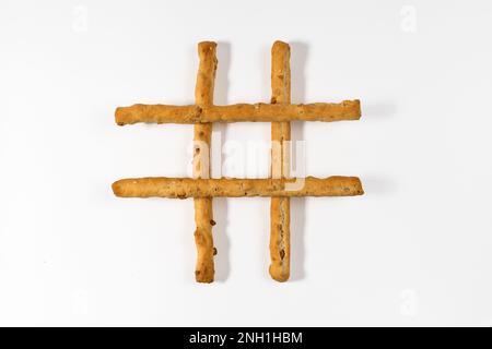 Top view of delicious thin long breadsticks placed on each other against white background with shadow Stock Photo