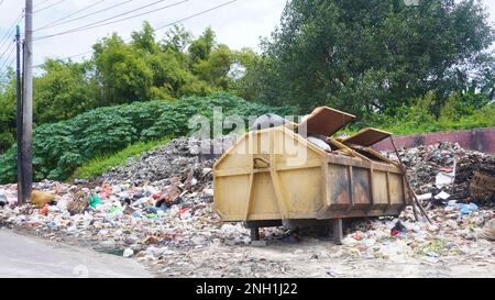 Surabaya, East Java, Indonesia - February, 2023 : piles of garbage in landfills with garbage can trash bin and dumpster at city rural village Stock Photo