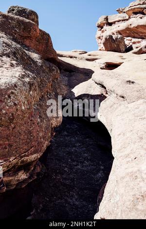 View of Rock Formation from Below Against Clear Blue Sky Stock Photo