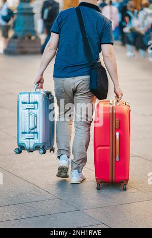 Unrecognizable young man traveling with two suitcases, travel and tourism concept Stock Photo