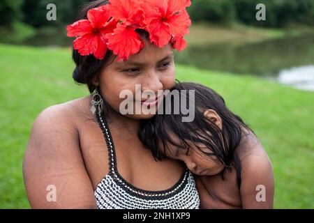 An indigenous Embera woman with her toddler asleep on her shoulder in an Embera village in Panama. Stock Photo
