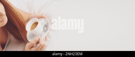 Woman having breakfast at home, she is lying on bed and drinking coffee Stock Photo
