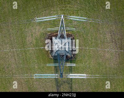 Aerial view of a metal electricity pylon standing in a dry, harvested ...