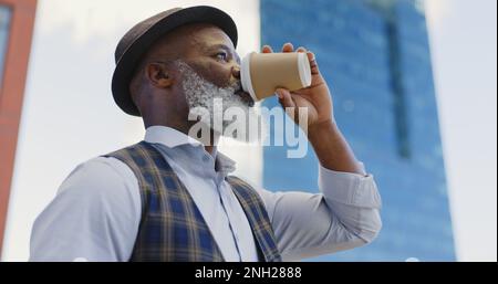 Black senior businessman, coffee and standing city for morning routine, positive mindset vision and remote travel for work. African man, drinking tea Stock Photo