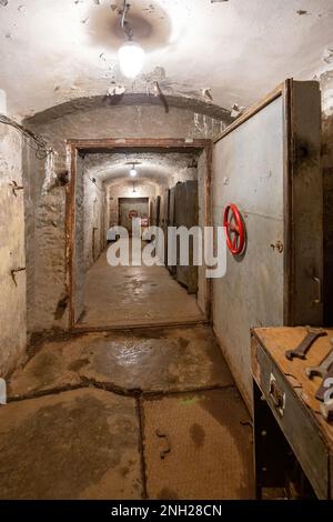 Hermetic rusty door of the bunker in underground abandoned tunnel. Mysterious old iron gate. Secret entrance Stock Photo