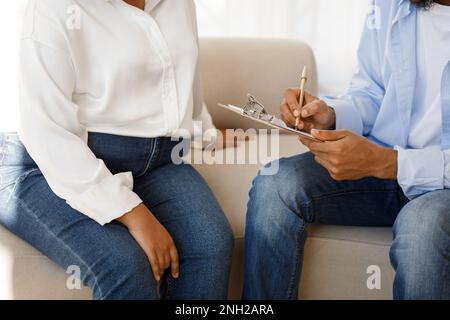 Unrecognizable black man counselor taking notes during therapy session Stock Photo