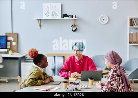 Diverse group of creative young people brainstorming project during meeting in office focus on Asian man with colored hair Stock Photo