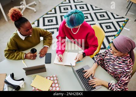 Top view at two creative team of three young people brainstorming project during meeting in office Stock Photo
