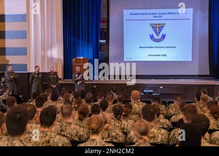 Rear Adm. Pete Garvin, Naval Education and Training Command (NETC), speaks to naval  aviation students as Rear Adm. Rich Brophy, Chief of Naval Air Training (CNATRA), looks on,  about the new Student Naval Aviator Junior Officer Course (SNAJOC) in the Naval Aviation  Schools Command’s (NASC) auditorium onboard Naval Air Station Pensacola, Dec. 8, 2022.  Garvin and Brophy both spoke about the new SNAJOC course, designed as a unified effort  between NETC and CNATRA to better equip junior aviation officers for their first tour in the fleet.  NETC’s mission is to recruit, train and deliver those w Stock Photo