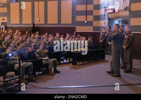 Rear Adm. Pete Garvin, Naval Education and Training Command (NETC), speaks to naval  aviation students as Rear Adm. Rich Brophy, Chief of Naval Air Training (CNATRA), looks on,  about the new Student Naval Aviator Junior Officer Course (SNAJOC) in the Naval Aviation  Schools Command’s (NASC) auditorium onboard Naval Air Station Pensacola, Dec. 8, 2022.  Garvin and Brophy both spoke about the new SNAJOC course, designed as a unified effort  between NETC and CNATRA to better equip junior aviation officers for their first tour in the fleet.  NETC’s mission is to recruit, train and deliver those w Stock Photo