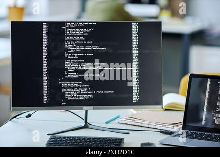 Front view background image of computer screen with code lines on desk in office Stock Photo